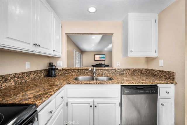 kitchen featuring dark countertops, dishwasher, a sink, recessed lighting, and white cabinetry