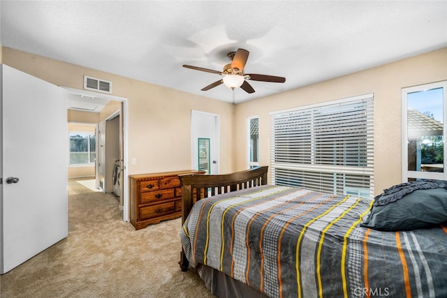 carpeted bedroom with visible vents and ceiling fan