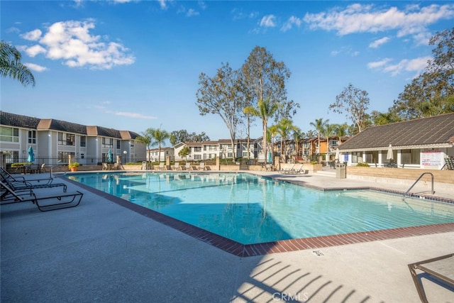 community pool with a patio area and a residential view