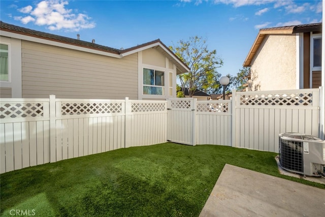 view of yard featuring a fenced backyard and central AC