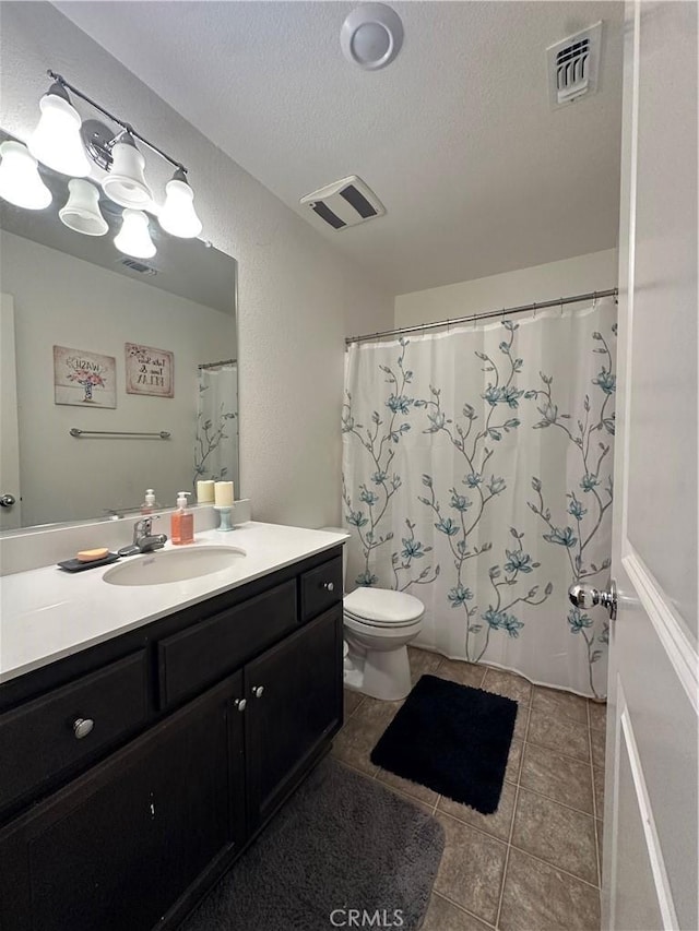 628 Marcus St, Merced, CA 95341 - full bath with vanity, toilet, tile patterned floors, a textured ceiling, and visible vents