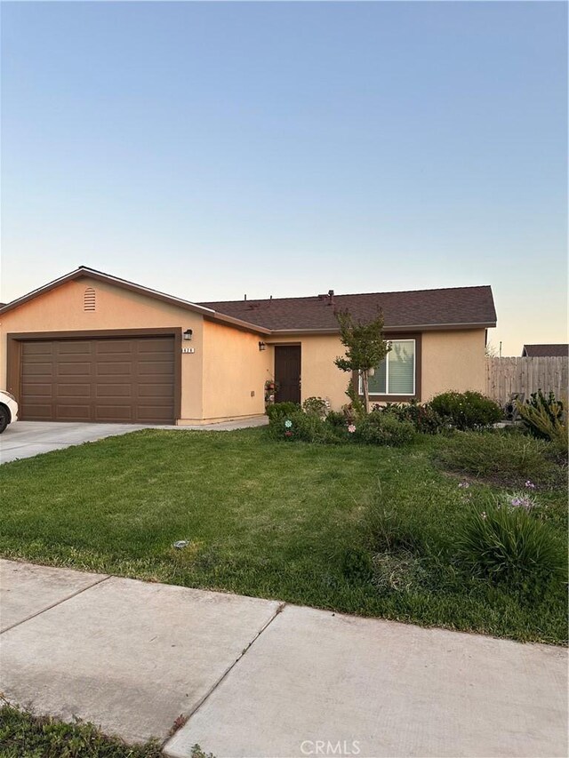 628 Marcus St, Merced, CA 95341 - ranch-style house with fence, a front yard, stucco siding, concrete driveway, and an attached garage