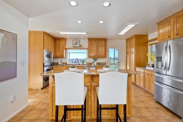kitchen with recessed lighting, appliances with stainless steel finishes, a breakfast bar area, and a kitchen island