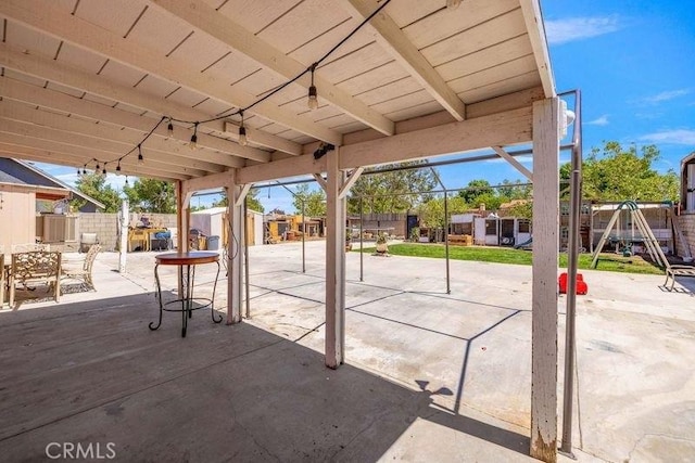 view of patio / terrace with a fenced backyard, outdoor dining space, an outbuilding, and a shed