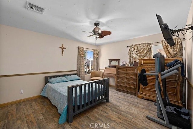 bedroom featuring baseboards, ceiling fan, wood-type flooring, and visible vents