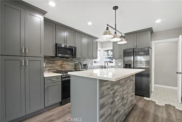 8165 Shadyside Ave, Whittier, CA 90606 - kitchen with appliances with stainless steel finishes, gray cabinets, wood finished floors, tasteful backsplash, and recessed lighting