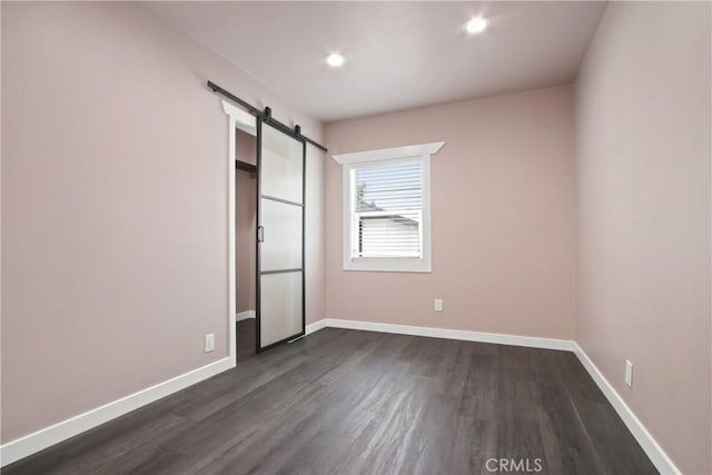 8165 Shadyside Ave, Whittier, CA 90606 - unfurnished bedroom with dark wood-style flooring, a barn door, baseboards, and recessed lighting