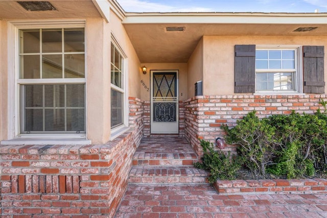 doorway to property featuring stucco siding