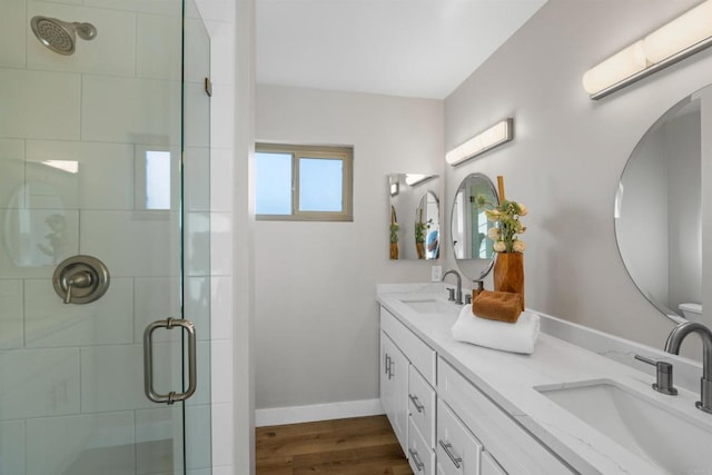 bathroom with wood finished floors, a wall unit AC, a sink, and a stall shower