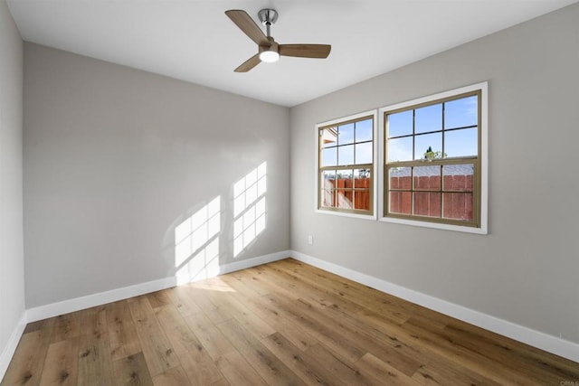unfurnished room featuring baseboards, wood-type flooring, and ceiling fan