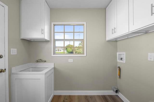 laundry room with baseboards, hookup for a washing machine, cabinet space, and a sink