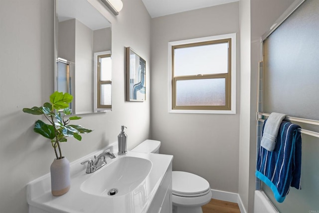full bath with vanity, wood finished floors, a wealth of natural light, and toilet