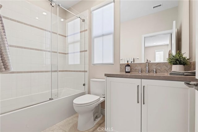 bathroom with visible vents, tasteful backsplash, vanity, toilet, and shower / bath combination with glass door