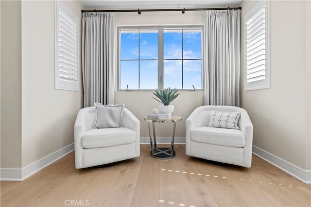 sitting room with baseboards and wood finished floors