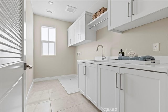 washroom featuring light tile patterned flooring, baseboards, visible vents, and a sink