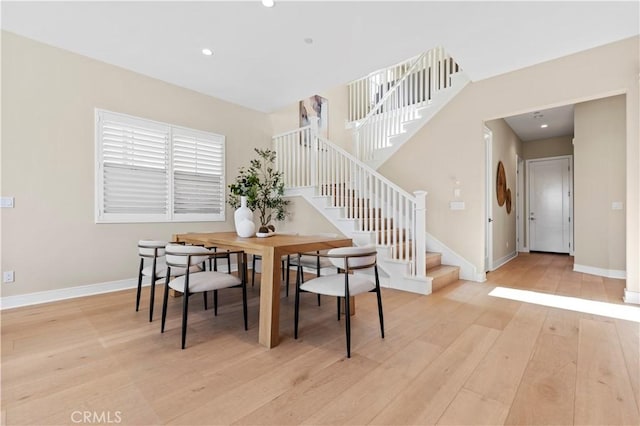 dining area with recessed lighting, baseboards, light wood finished floors, and stairs