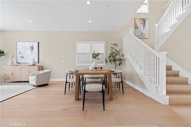 dining room with recessed lighting, baseboards, light wood finished floors, and stairway