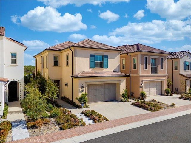 view of front of property featuring an attached garage, concrete driveway, a tile roof, and stucco siding