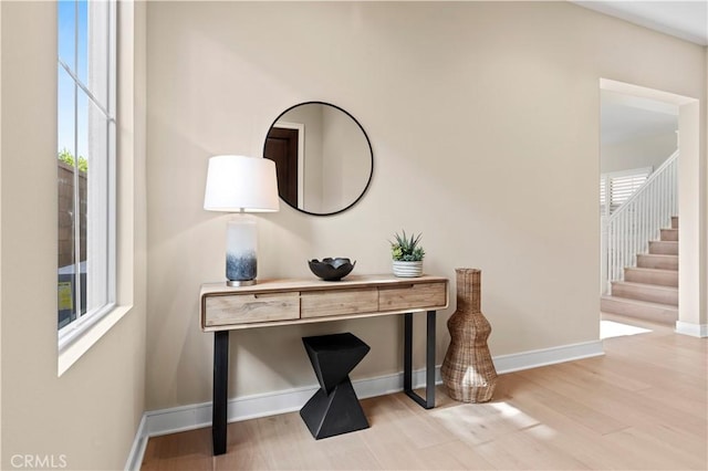 interior space with a healthy amount of sunlight, baseboards, and wood finished floors