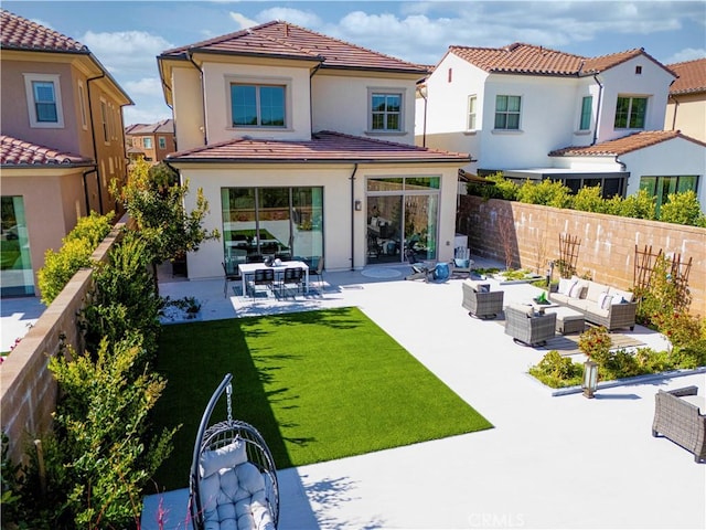 rear view of house with an outdoor living space, a patio area, fence, a yard, and stucco siding