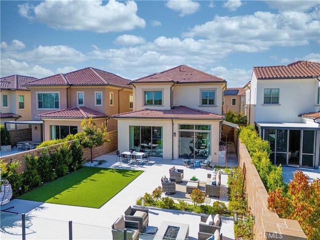 rear view of house with a tiled roof, a patio area, a fenced backyard, an outdoor hangout area, and stucco siding