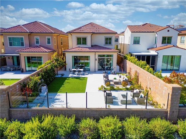 back of property featuring a fenced backyard, a patio area, stucco siding, and a tile roof