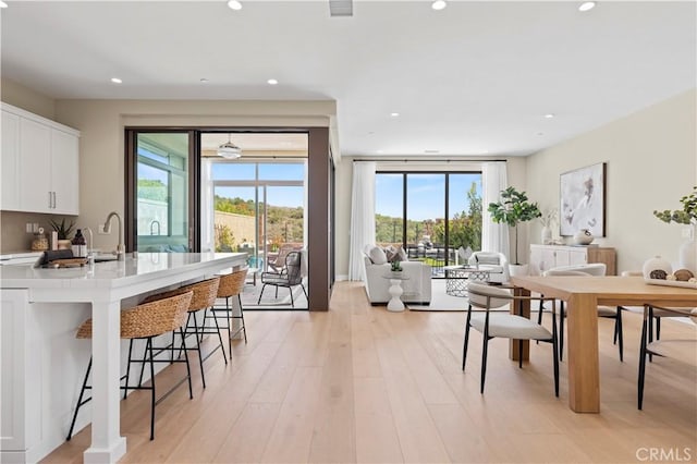 dining room with recessed lighting, a wealth of natural light, and light wood finished floors