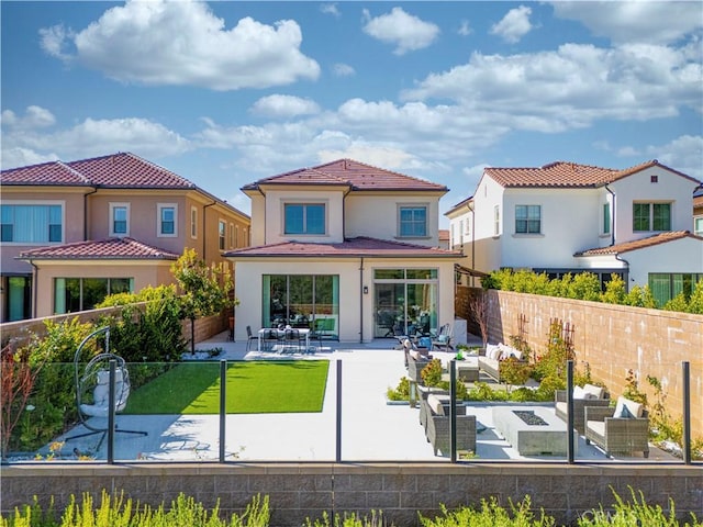 rear view of house featuring a fenced backyard, a patio area, and stucco siding