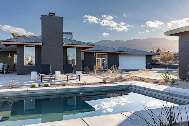rear view of property featuring a mountain view and a patio