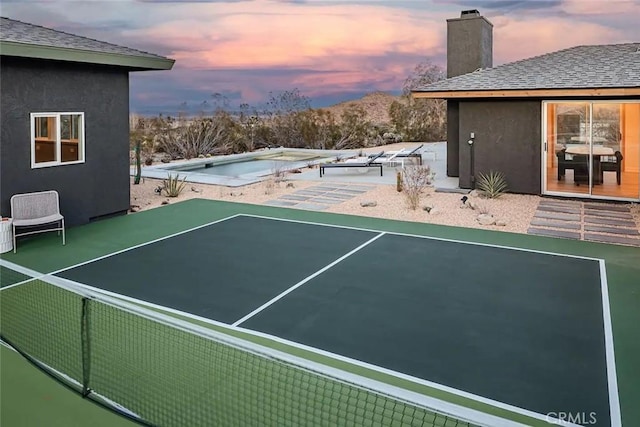 view of tennis court featuring a hot tub and a mountain view
