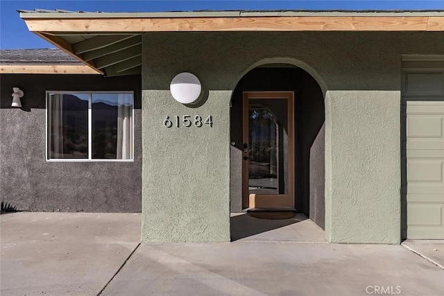 entrance to property featuring stucco siding