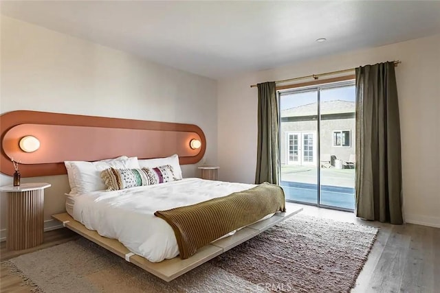 bedroom with access to outside, baseboards, and wood finished floors