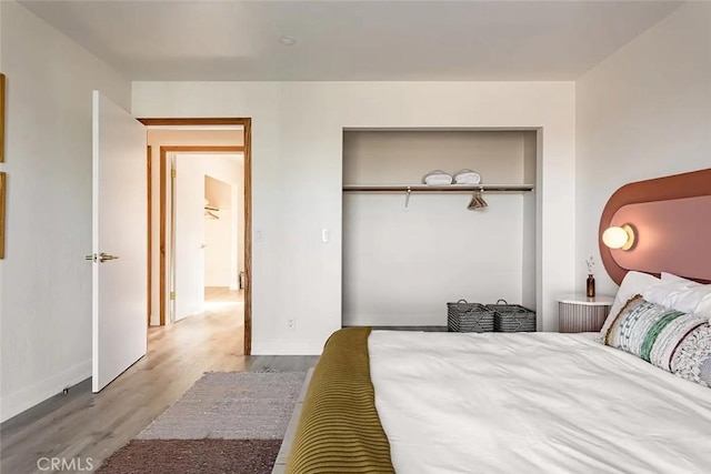 bedroom featuring a closet, baseboards, and wood finished floors