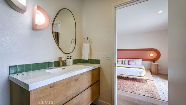 61584 Pueblo Trl, Joshua Tree, CA 92252 - ensuite bathroom featuring wood finished floors, vanity, and baseboards