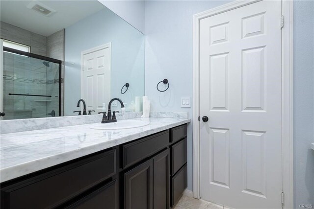 68245 Peladora Rd, Cathedral City, CA 92234 - bathroom with vanity, tile patterned flooring, tiled shower, and visible vents