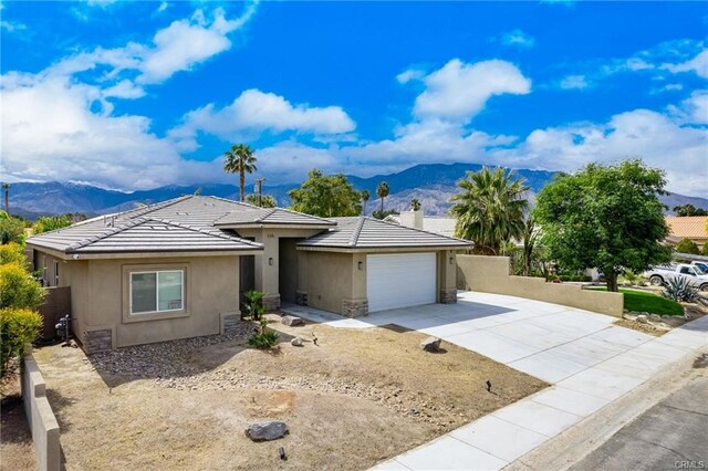 68245 Peladora Rd, Cathedral City, CA 92234 - single story home with a garage, stucco siding, a mountain view, driveway, and a tile roof