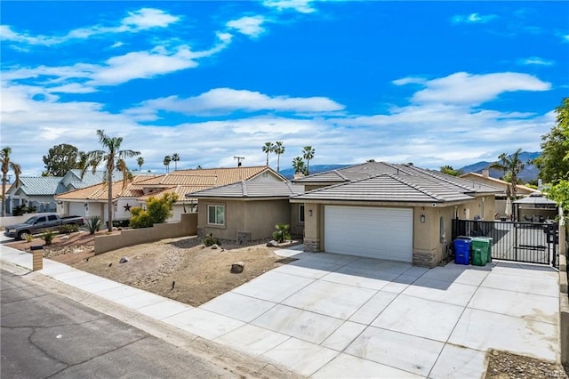 68245 Peladora Rd, Cathedral City, CA 92234 - single story home featuring an attached garage, stone siding, stucco siding, a gate, and driveway