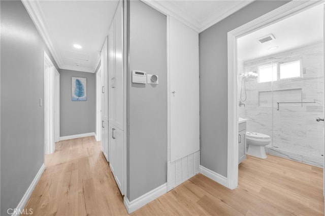 hall featuring crown molding, visible vents, and light wood-style floors