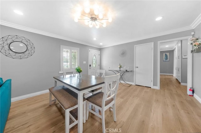 dining room with an inviting chandelier, baseboards, crown molding, and light wood-type flooring