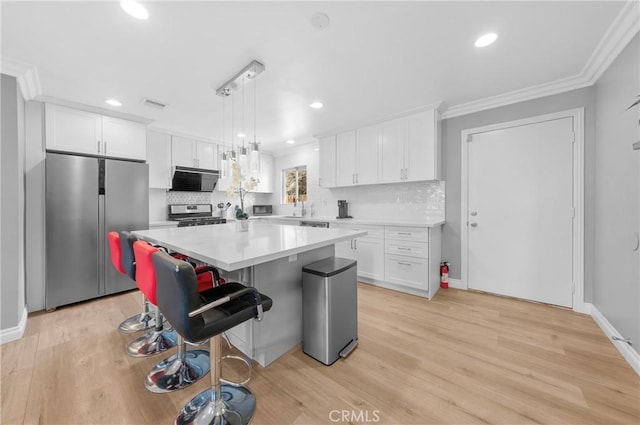 kitchen featuring crown molding, stainless steel appliances, white cabinets, and decorative backsplash