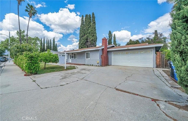 single story home featuring fence, a garage, stucco siding, a chimney, and driveway