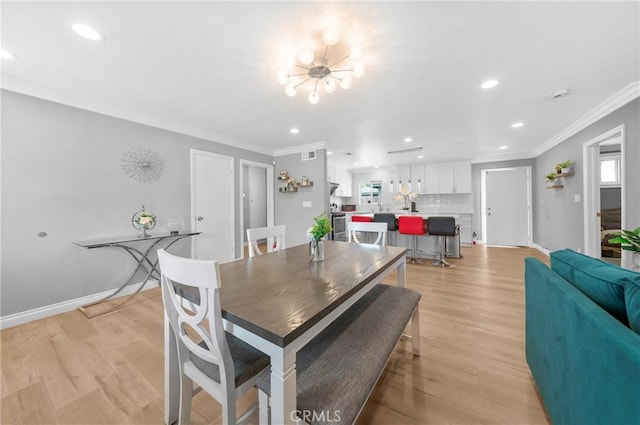 dining space with crown molding, recessed lighting, an inviting chandelier, and light wood-style flooring