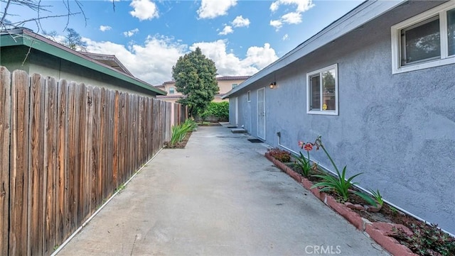 view of home's exterior featuring fence, a patio area, and stucco siding