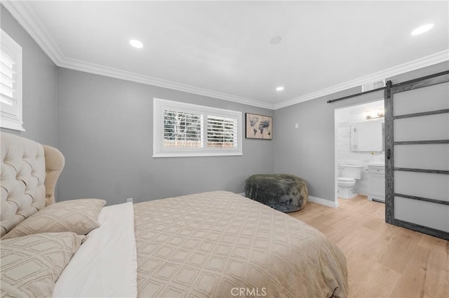 bedroom with crown molding, connected bathroom, a barn door, light wood finished floors, and recessed lighting