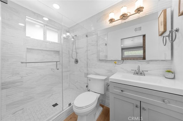 full bathroom featuring visible vents, tile walls, a stall shower, wood finished floors, and toilet