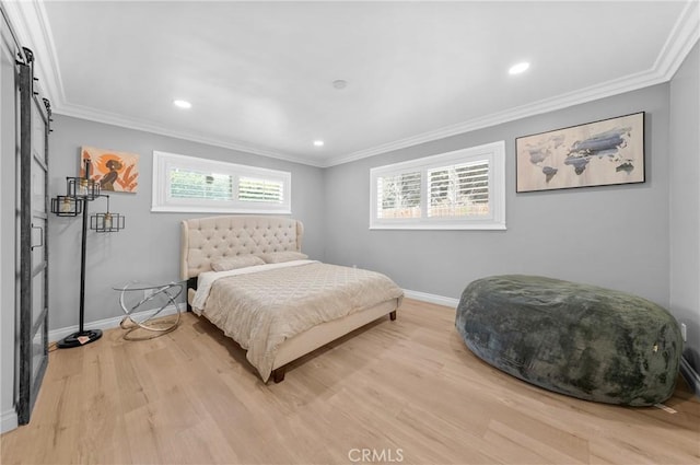 bedroom with baseboards, a barn door, light wood-style flooring, and ornamental molding