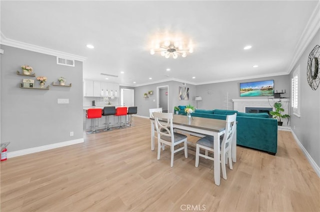 dining area with light wood-style floors, baseboards, indoor wet bar, and recessed lighting