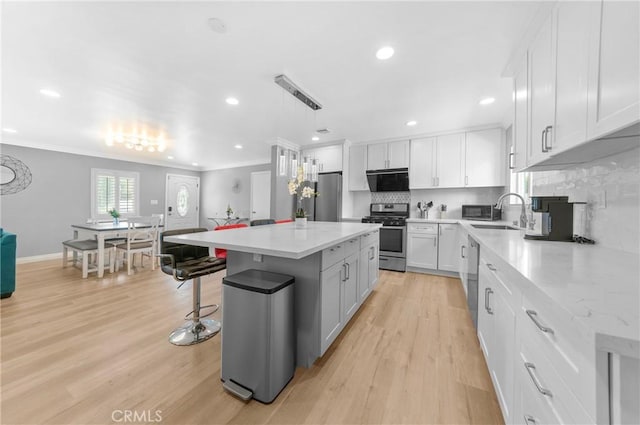 kitchen featuring decorative backsplash, stainless steel appliances, ornamental molding, and a kitchen island