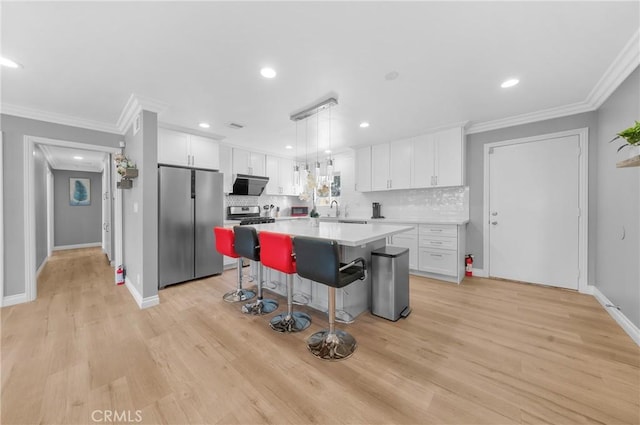 kitchen featuring a center island, backsplash, white cabinets, and stainless steel appliances