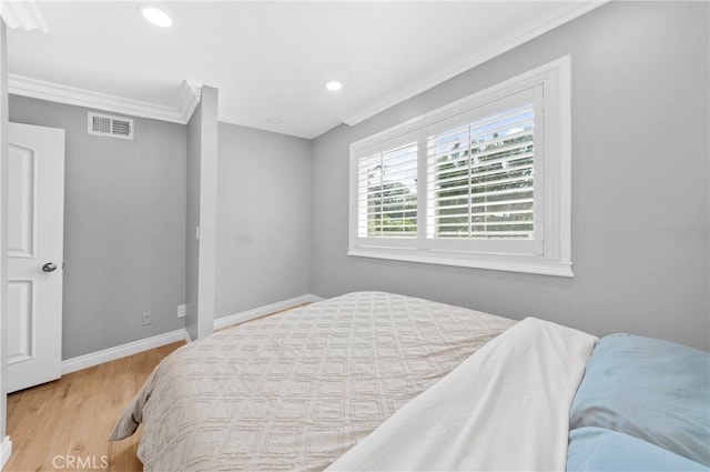 bedroom with crown molding, visible vents, wood finished floors, baseboards, and recessed lighting